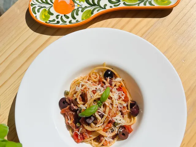 Spaghetti Puttanesca, bord spaghetti puttanesca met olijven en kappertjes